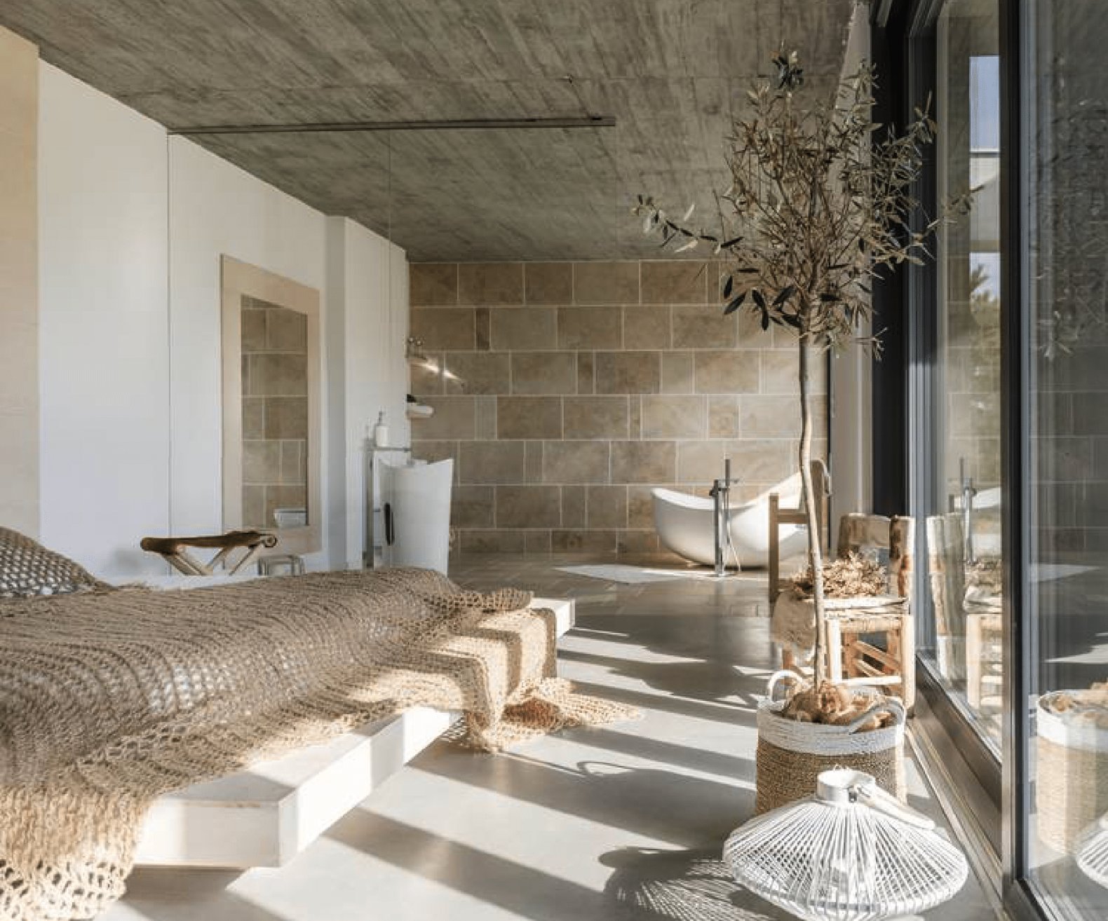 Origin, Assagao — bedroom suite opening to a freestanding bathtub in natural stone