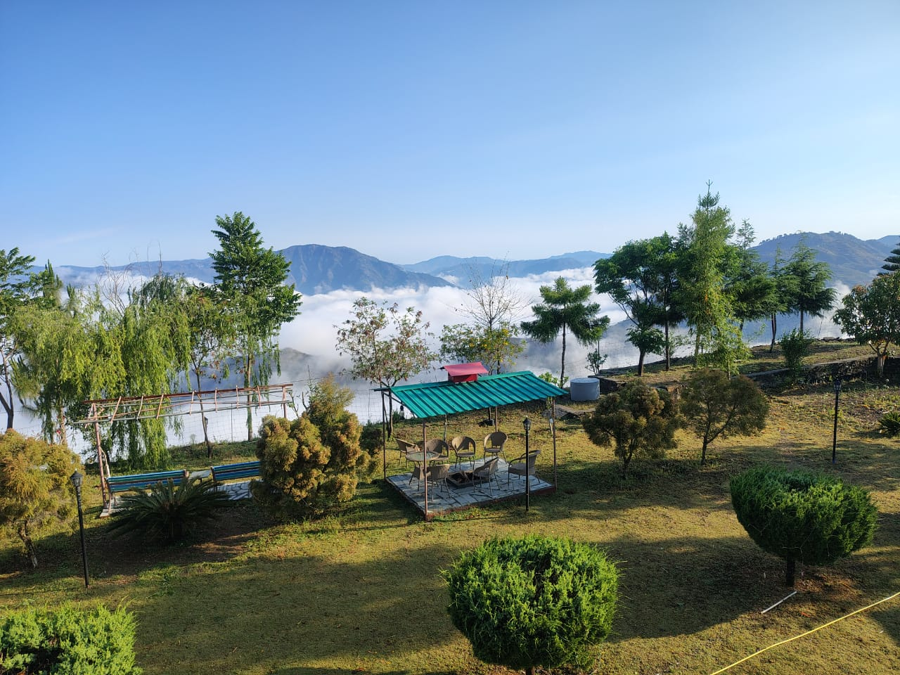 Hillside gardens and gazebo overlooking a sea of clouds at Oorja Eco Retreat